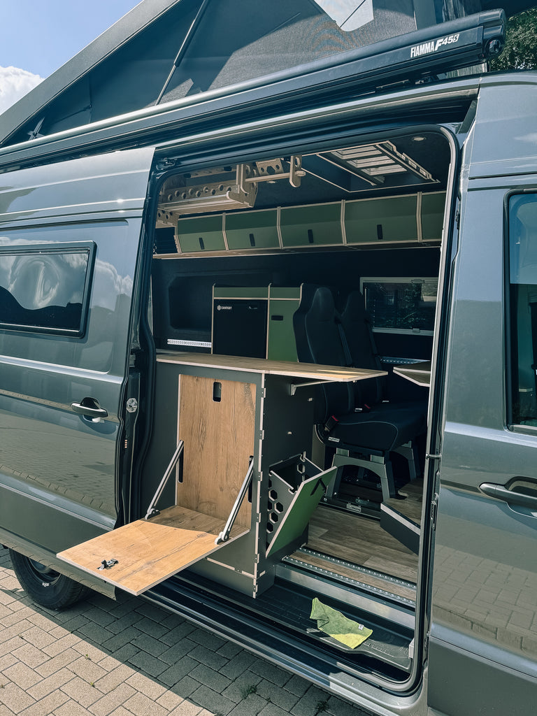 Küche mit Arbeitsplattenerweiterung und Außentisch im MAN TGE Camper